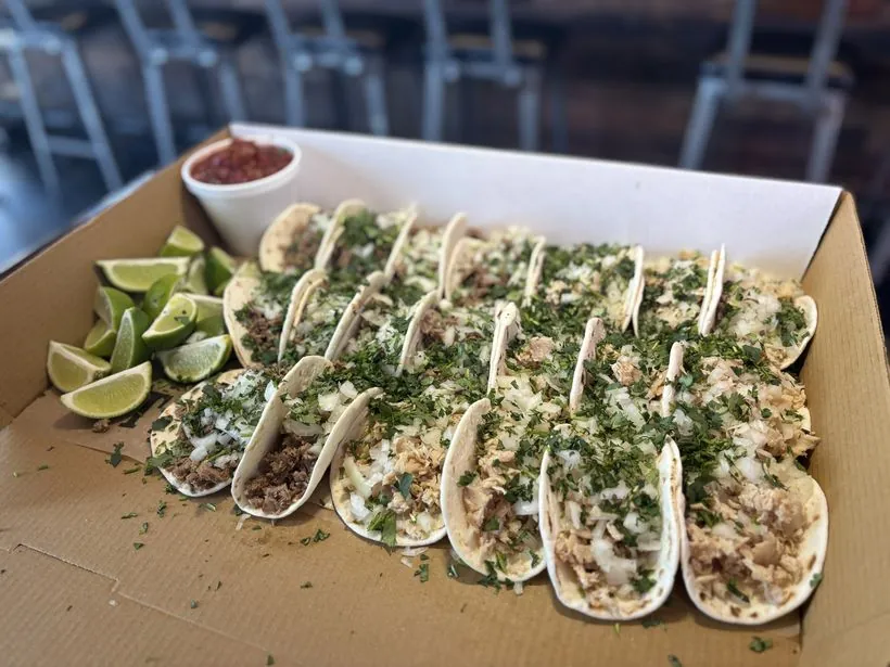 Taco catering tray — cheesesteak tacos with cilantro, onion, lime and salsa