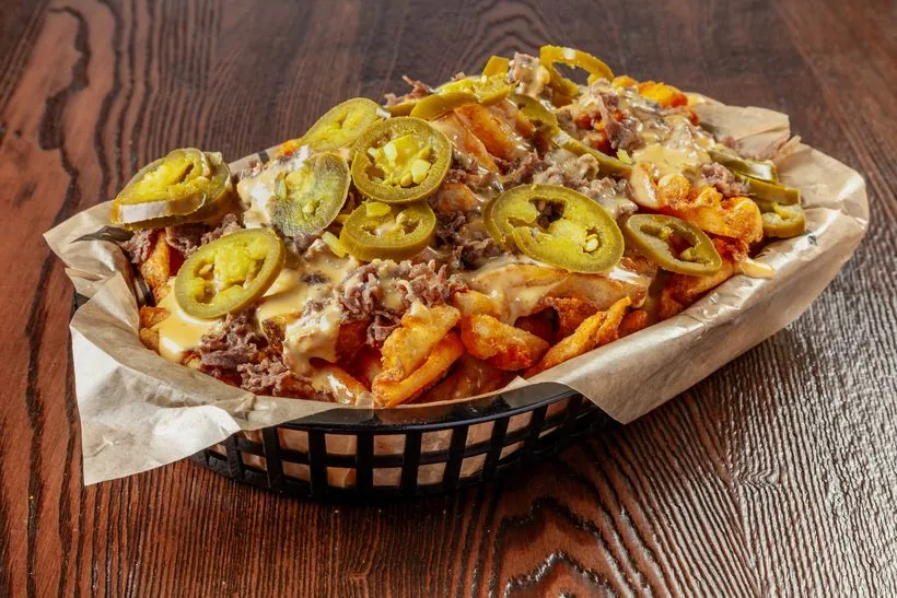 Famous Philly Cheese Fries — waffle fries loaded with beef, queso and jalapenos